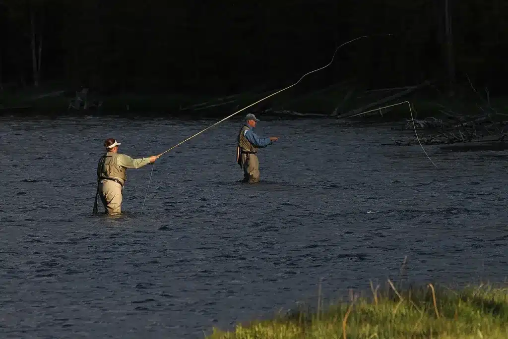 Anglers fly fishing in a river in lightweight layers