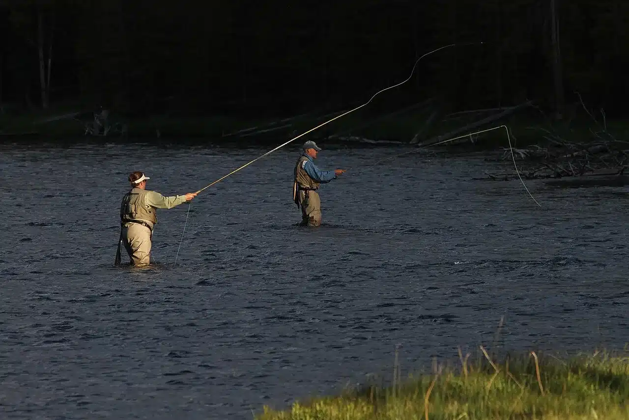 Two anglers fly fishing in a river wearing lightweight outdoor layers